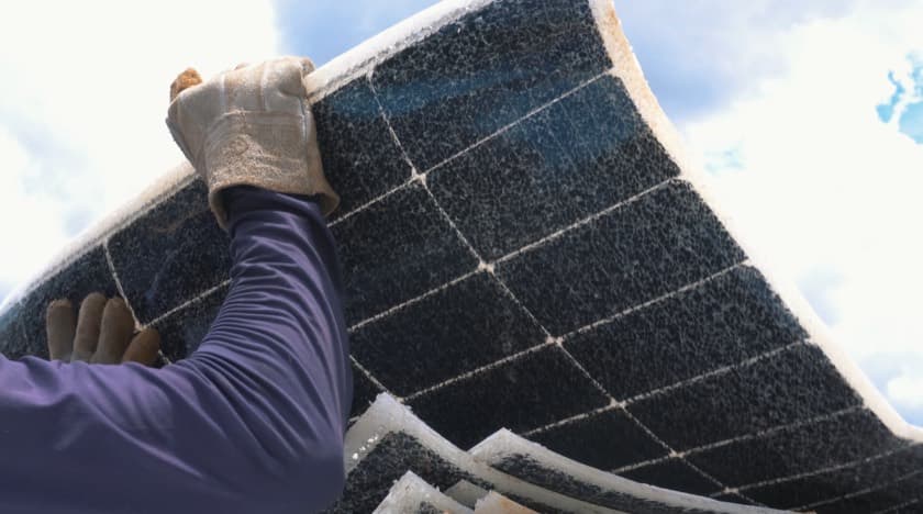 Técnico segura módulo fotovoltaico flexionado e danificado contra o céu